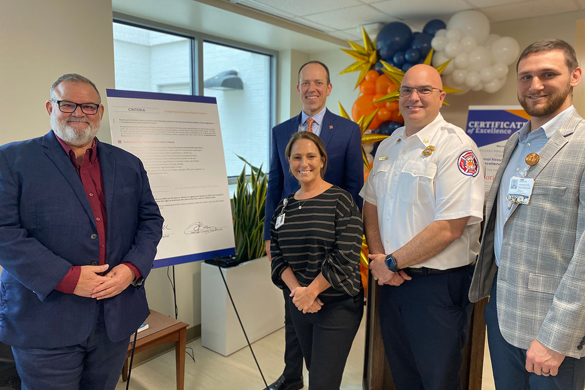 A group of people in a room with a poster board behind them with information